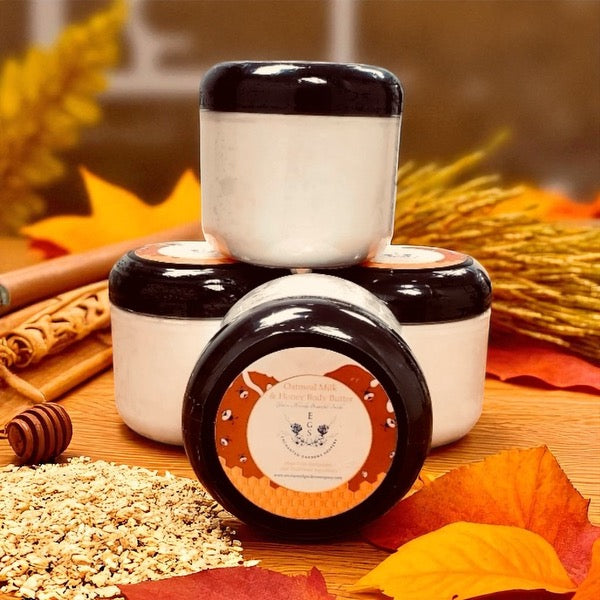 Three jars with black lids on a wooden surface with autumn leaves and spices.